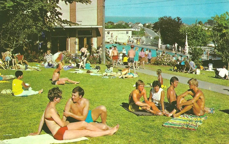 1970s postcard of Pontins south Devon holiday camp showing people relaxing on grass