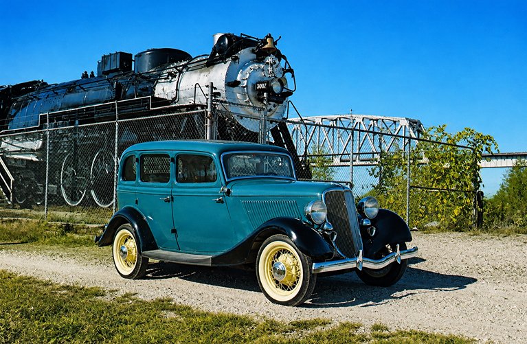 A Ford V8 from the antique auto museum posing next to the Hudson steam locomotive #3007 on Quinsippi Island in Quincy